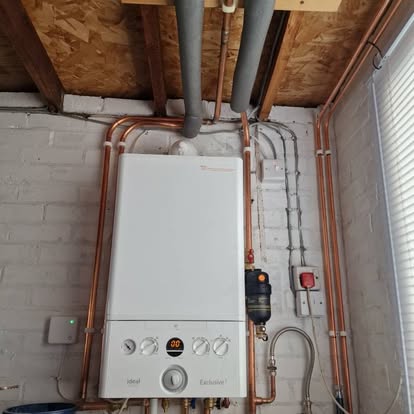 Newly installed wall-mounted combi boiler with copper pipework